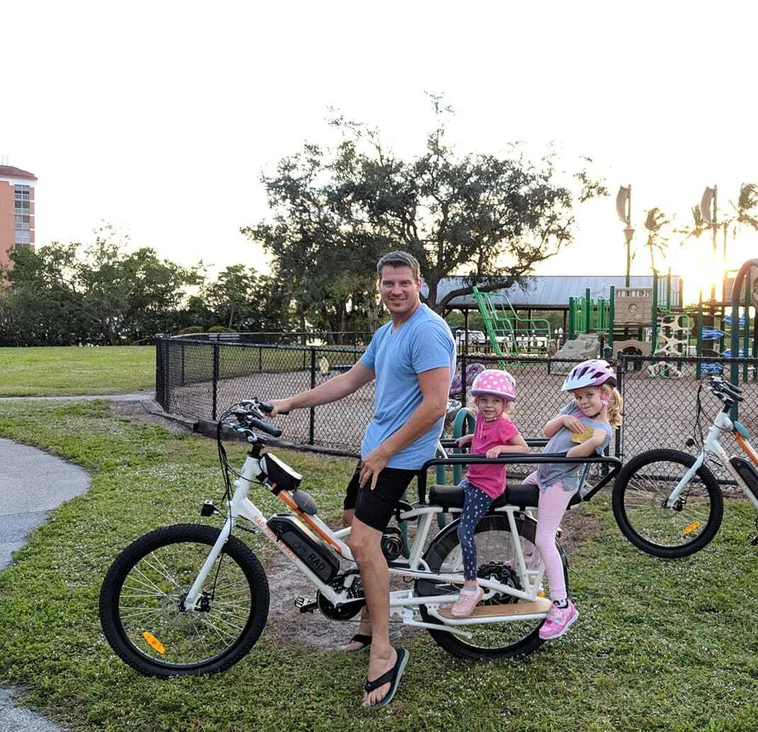 Scott Carr riding an electric bike with his daughters
