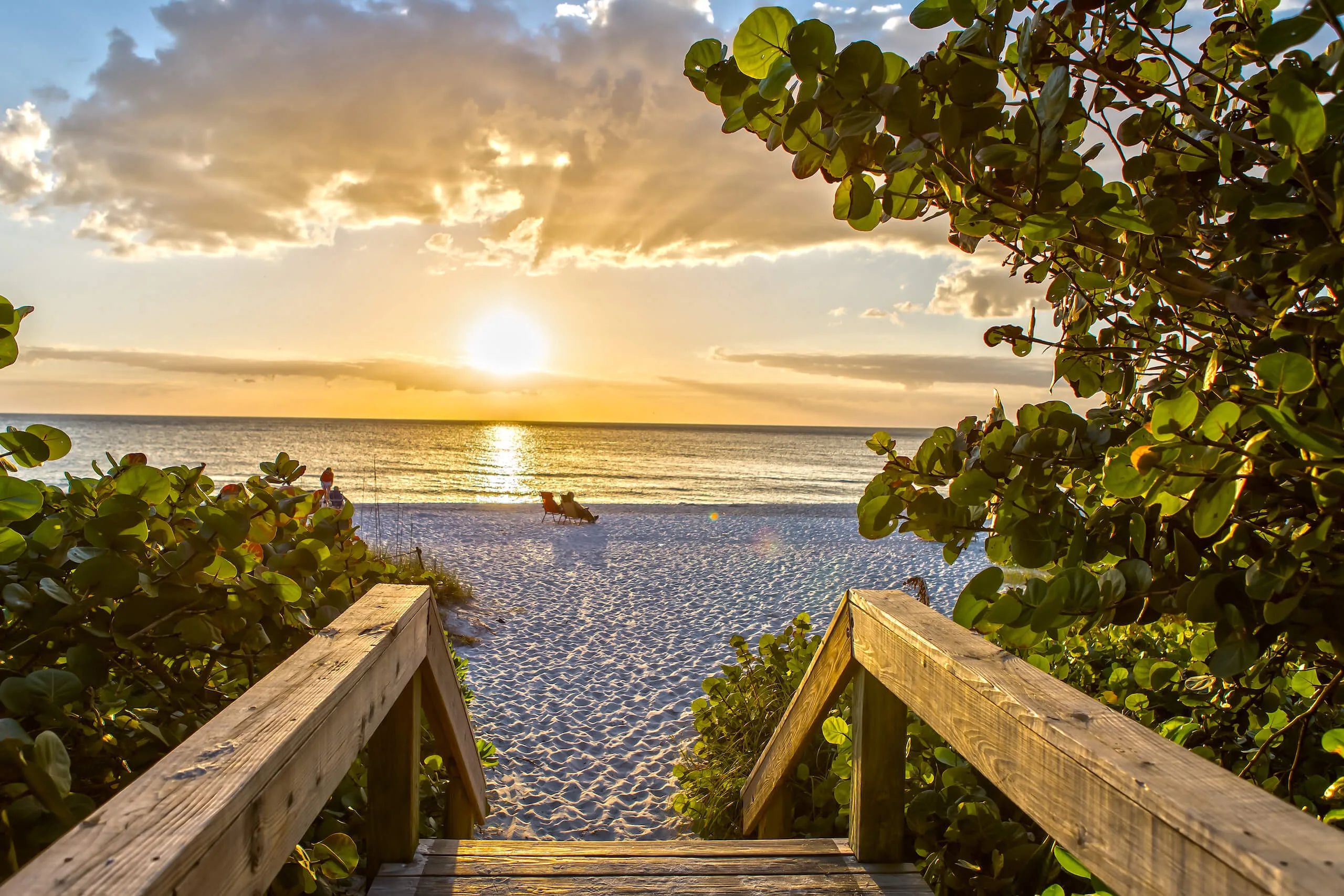 Boardwalk onto a Naples beach at sunset